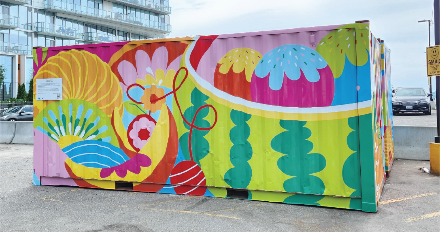 A mural-covered shipping container in a parking lot. 