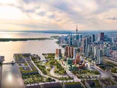 Artists rendering of a neighbourhood made up of buildings of varying heights, surrounded by parks and a river.