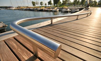 close up view showing the curved railing of a WaveDeck with a park in the background