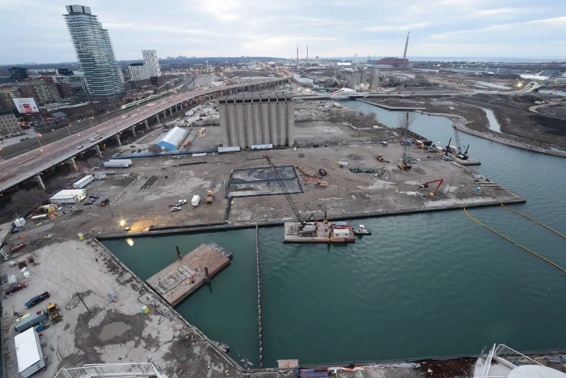 Construction progress at Parliament Slip with expanded lakefill, barges transporting material, and ongoing dockwall installation.  2/5