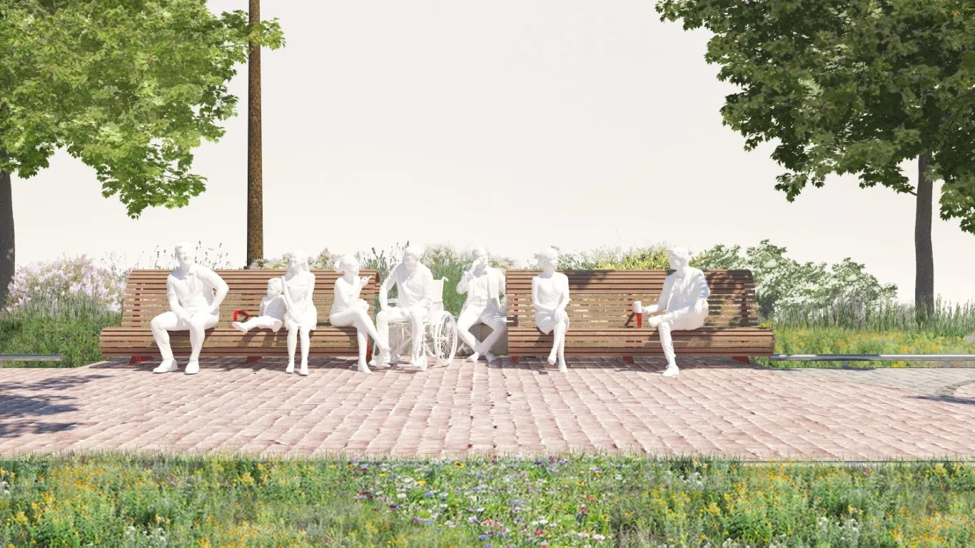 A group of white sculpted human figures sits on two long wooden benches facing forward, with ample space between the benches to accommodate a wheelchair user. The inclusive seating area is located on a paved section of the Water's Edge Promenade, surrounded by greenery and shaded by trees.