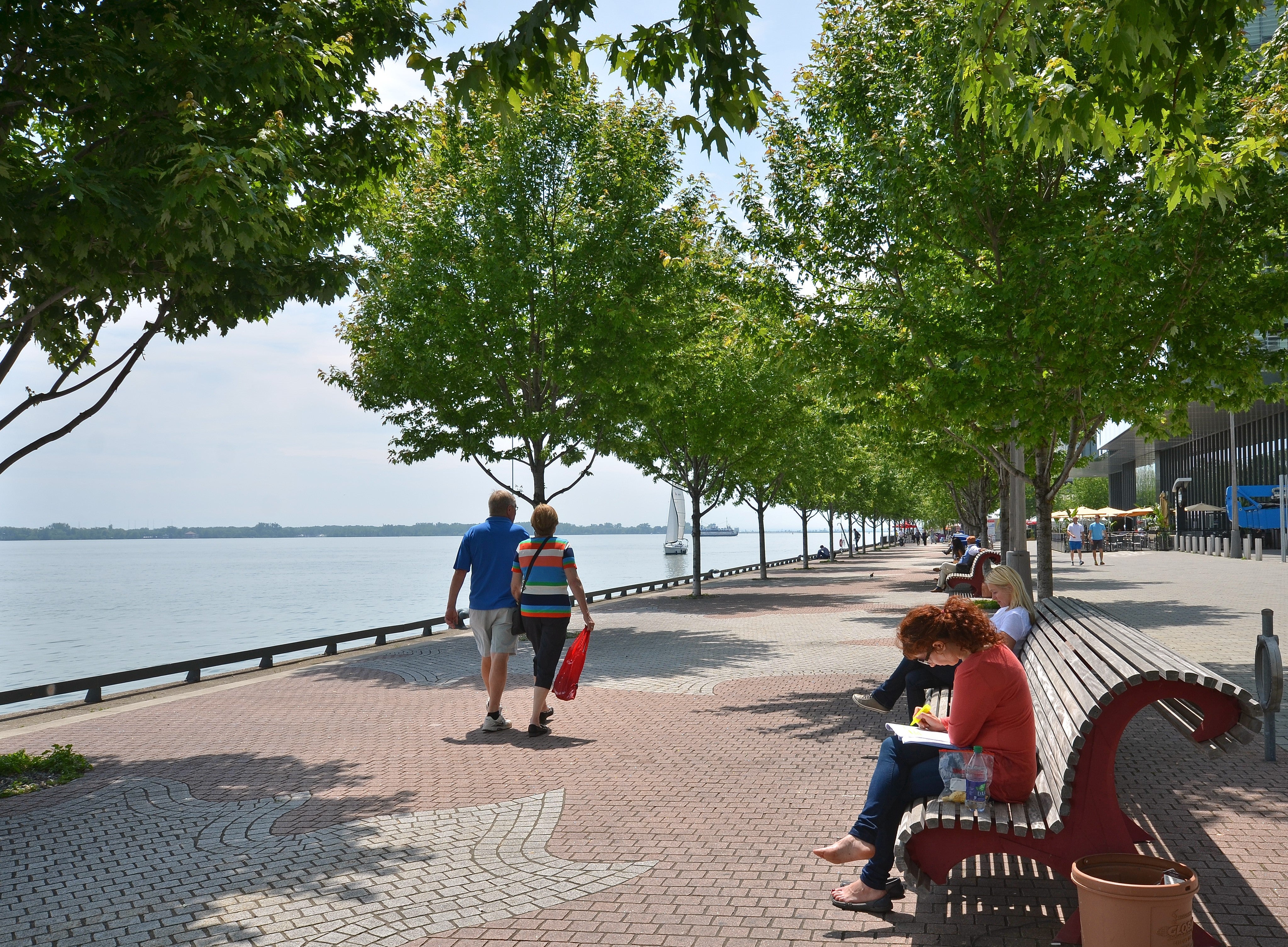 people strolling along the water's edge promenade