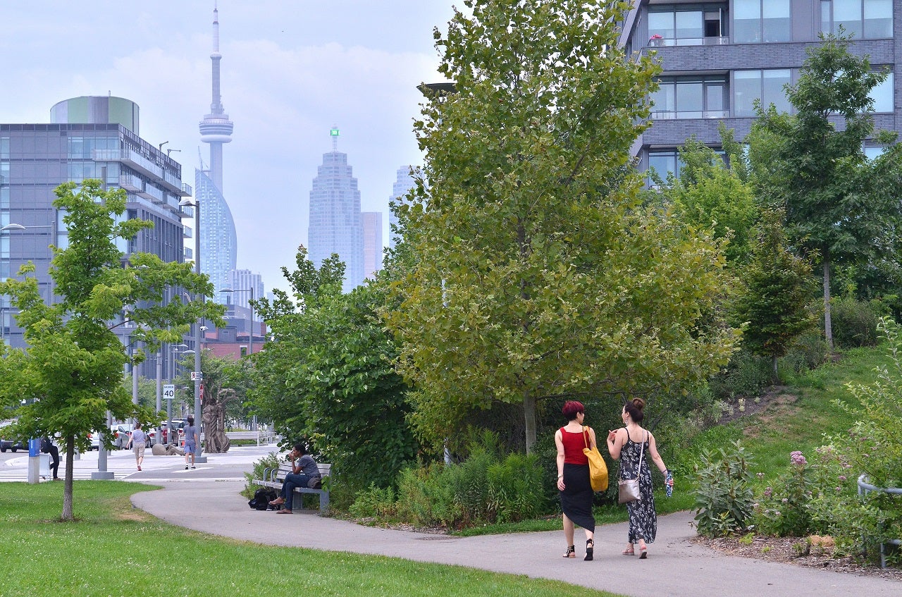 Two women walking strolling along a park trail