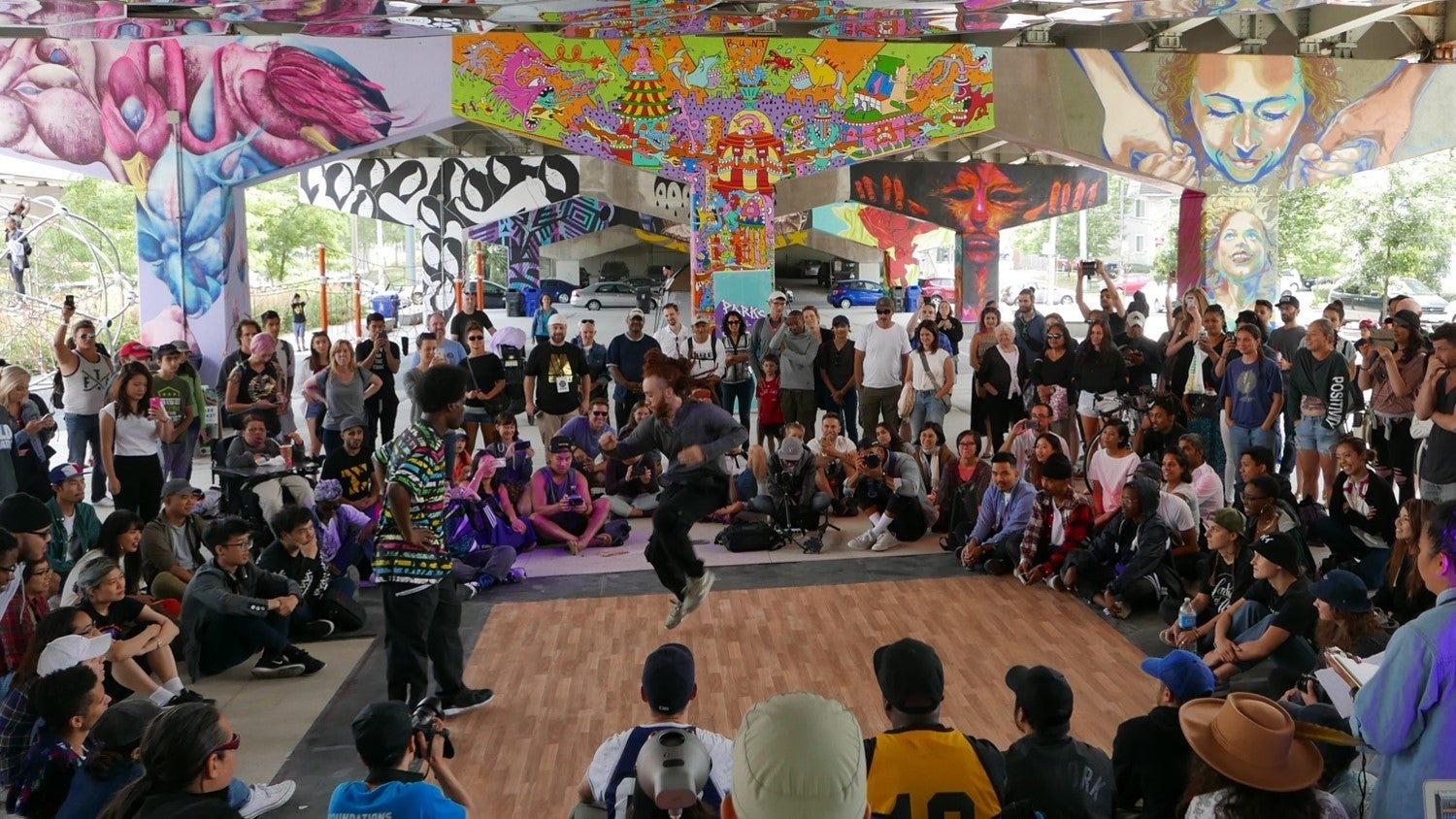 a crowd of people watching a street performer at Underpass Park