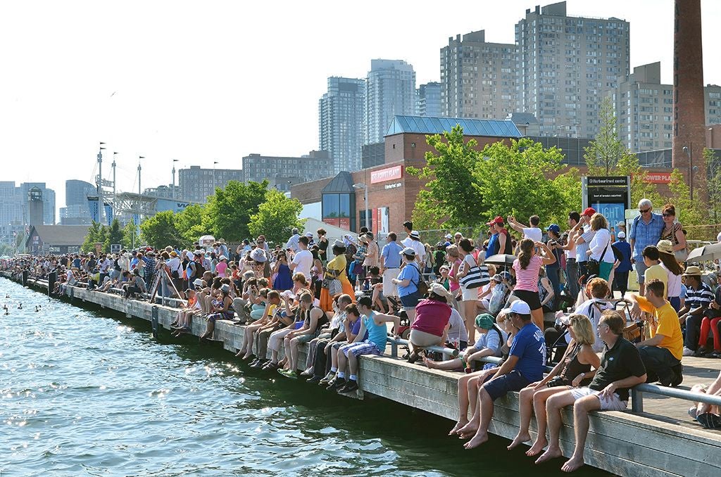 people sitting along the dockwall at the water's edge