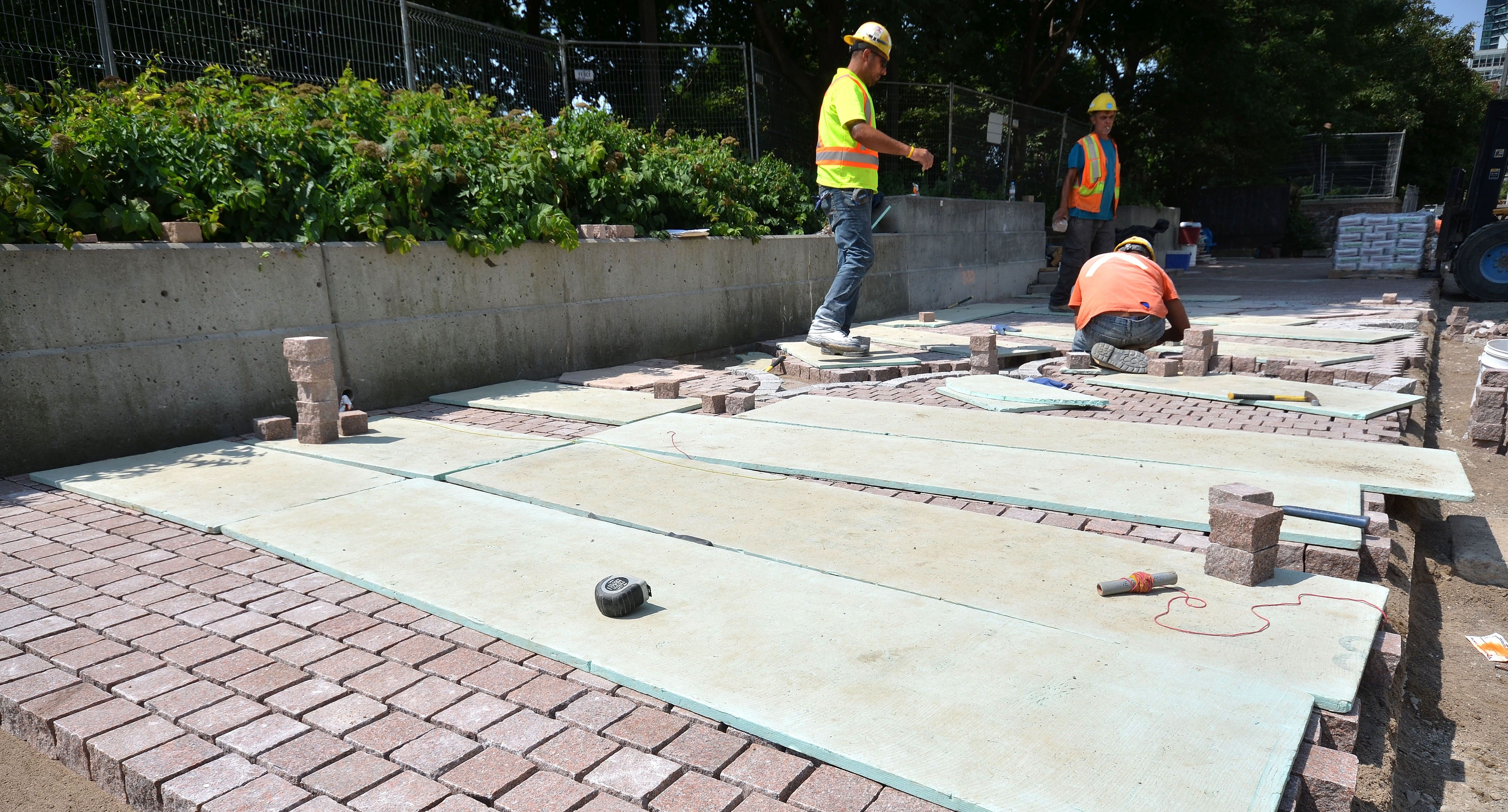 construction crews laying granite pavers