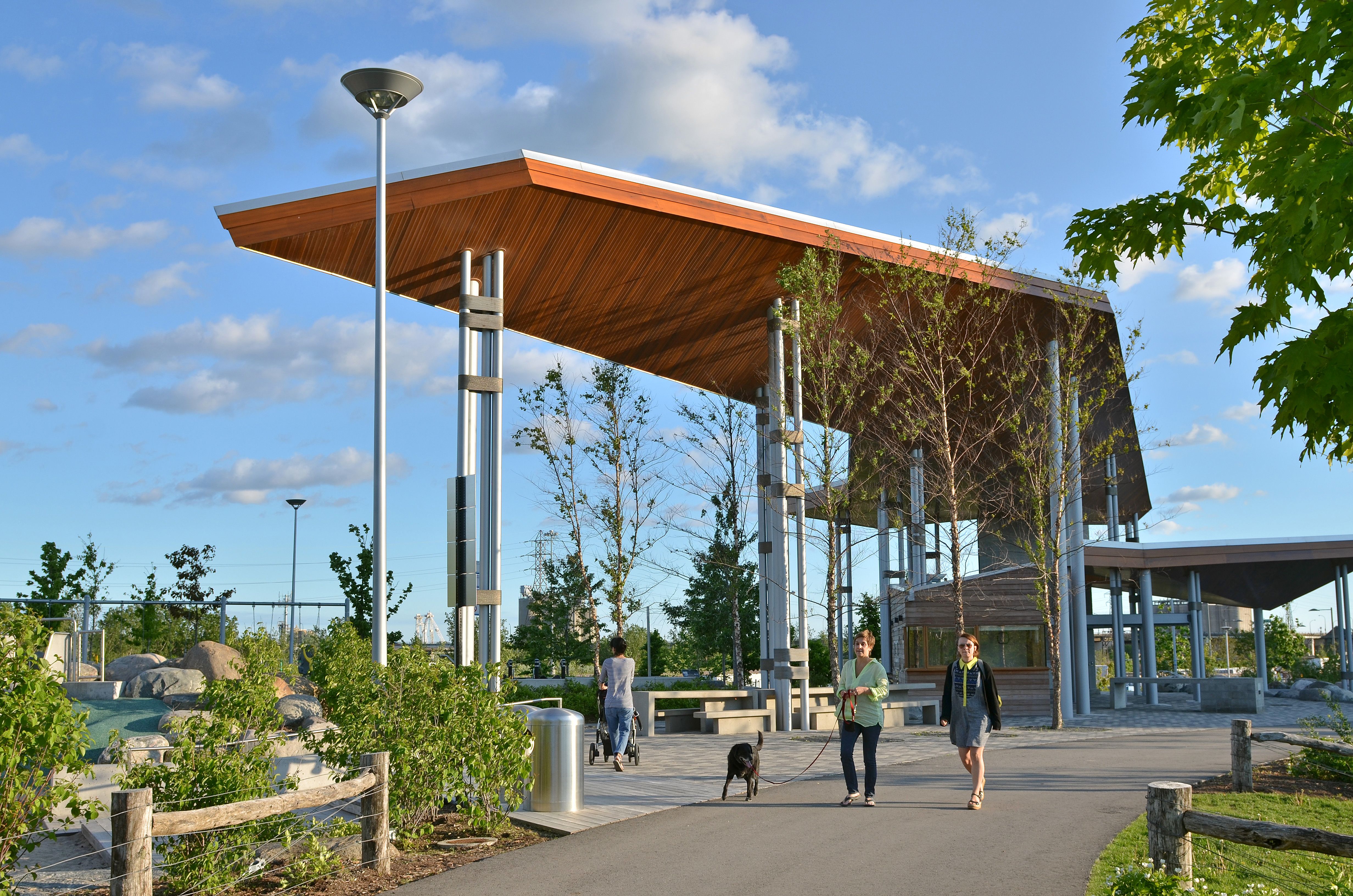 people walking along a path near an outdoor pavilion