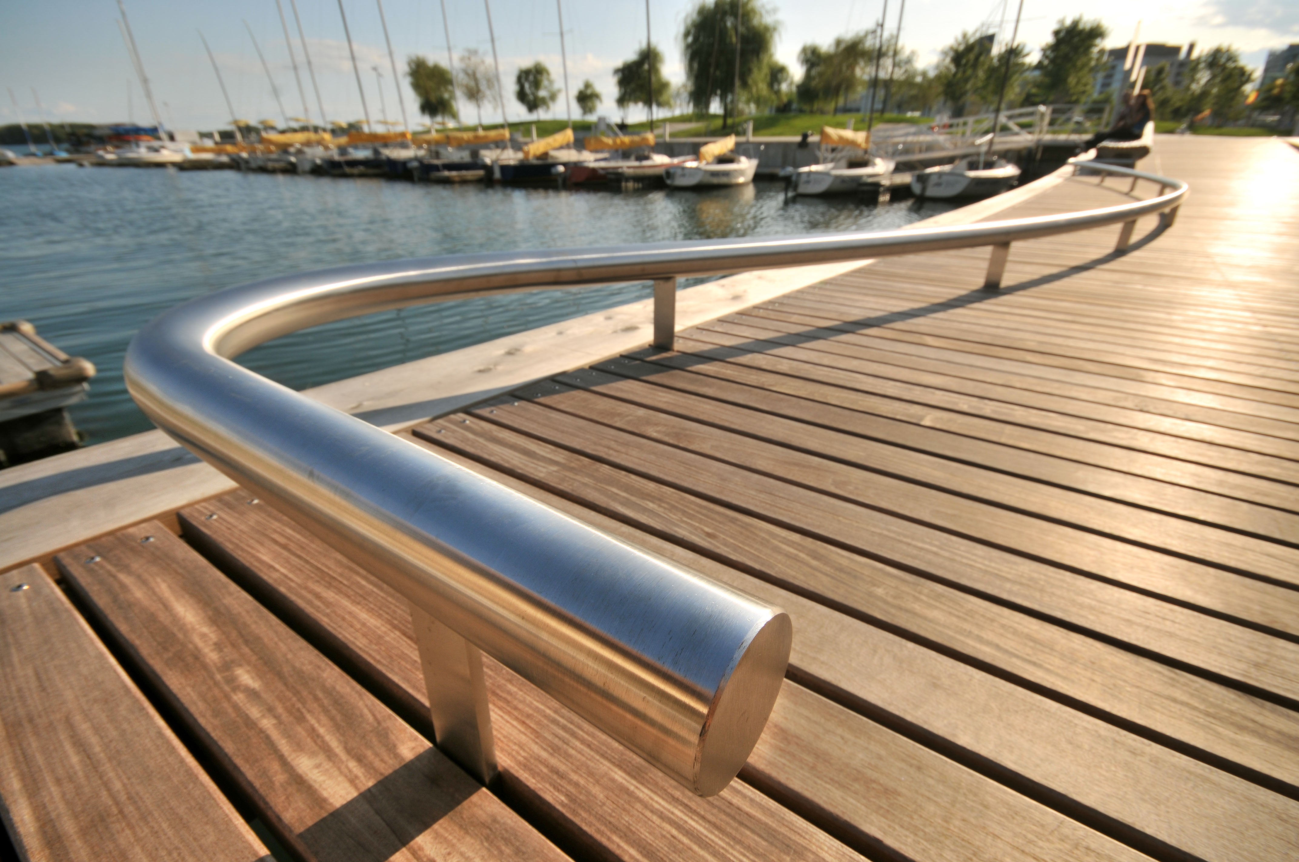 close up view showing the curved railing of a WaveDeck with a park in the background