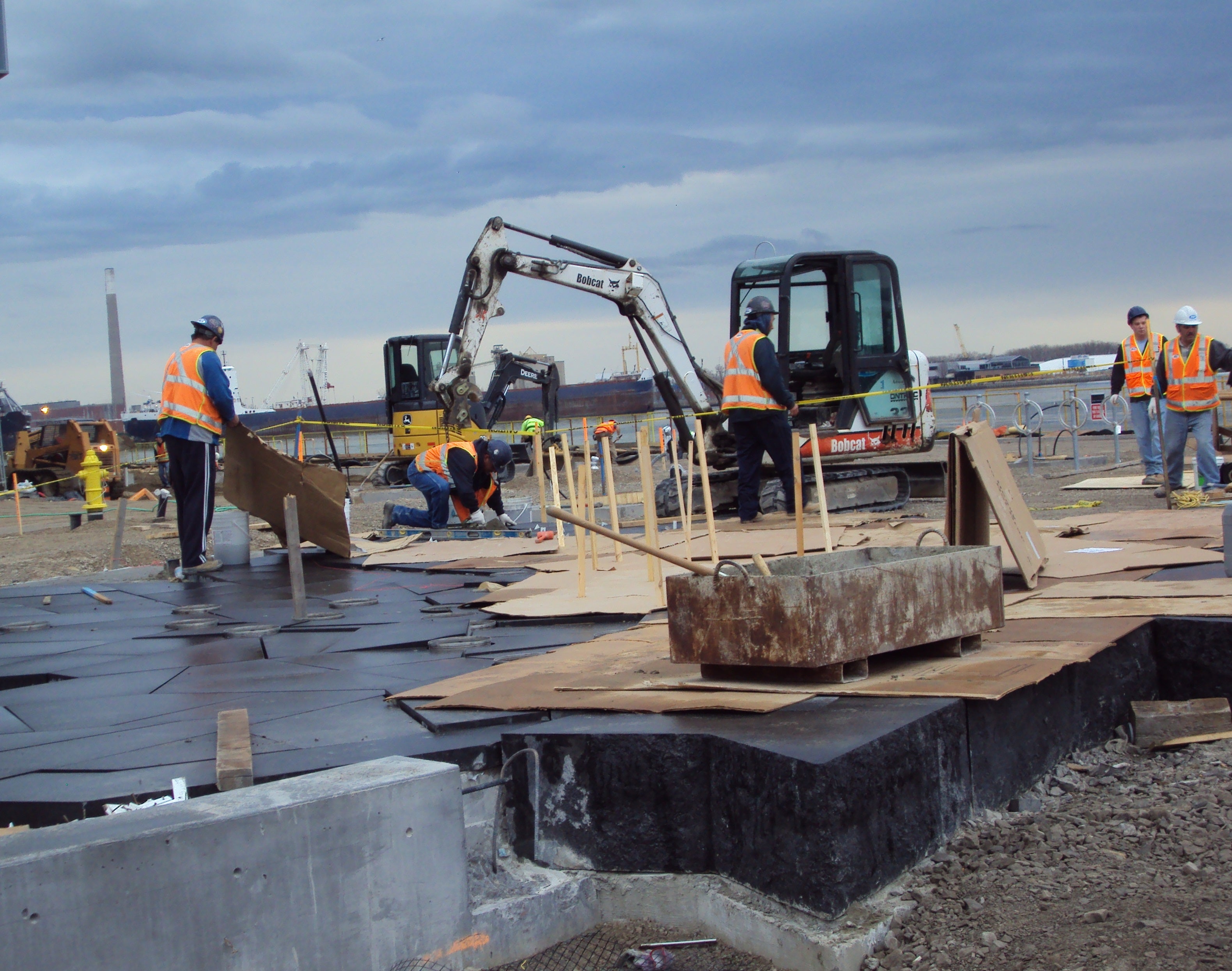 Construction crews working with equipment along the waterfront