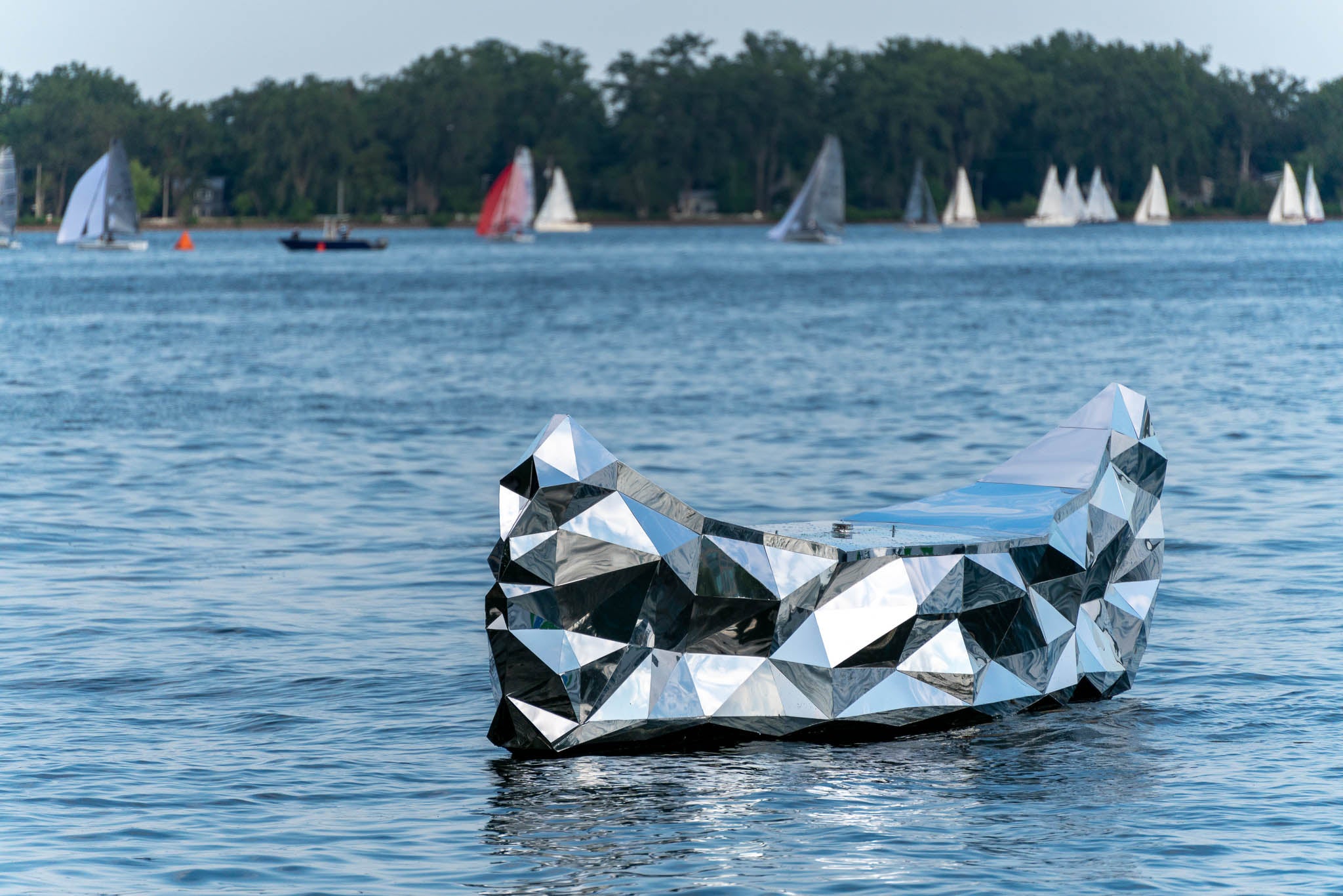 a photo of a floating public art piece that resembles a mirrored canoe in Lake Ontario 