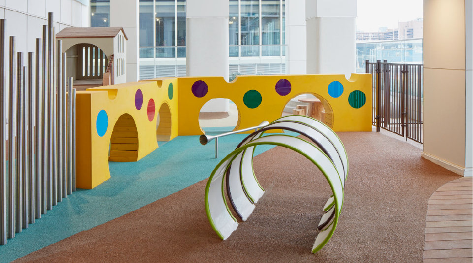 A children's play area with a window view of a building in the background.