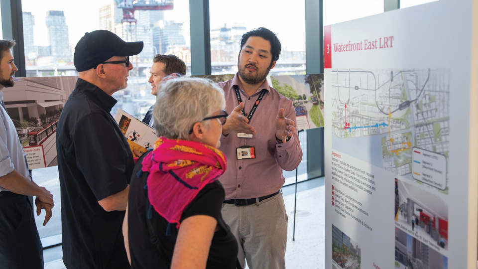 Three people standing in front of a informational poster. 