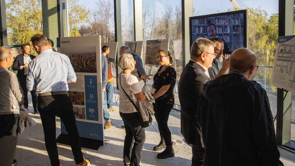 A crowd of people standing around informational posters.