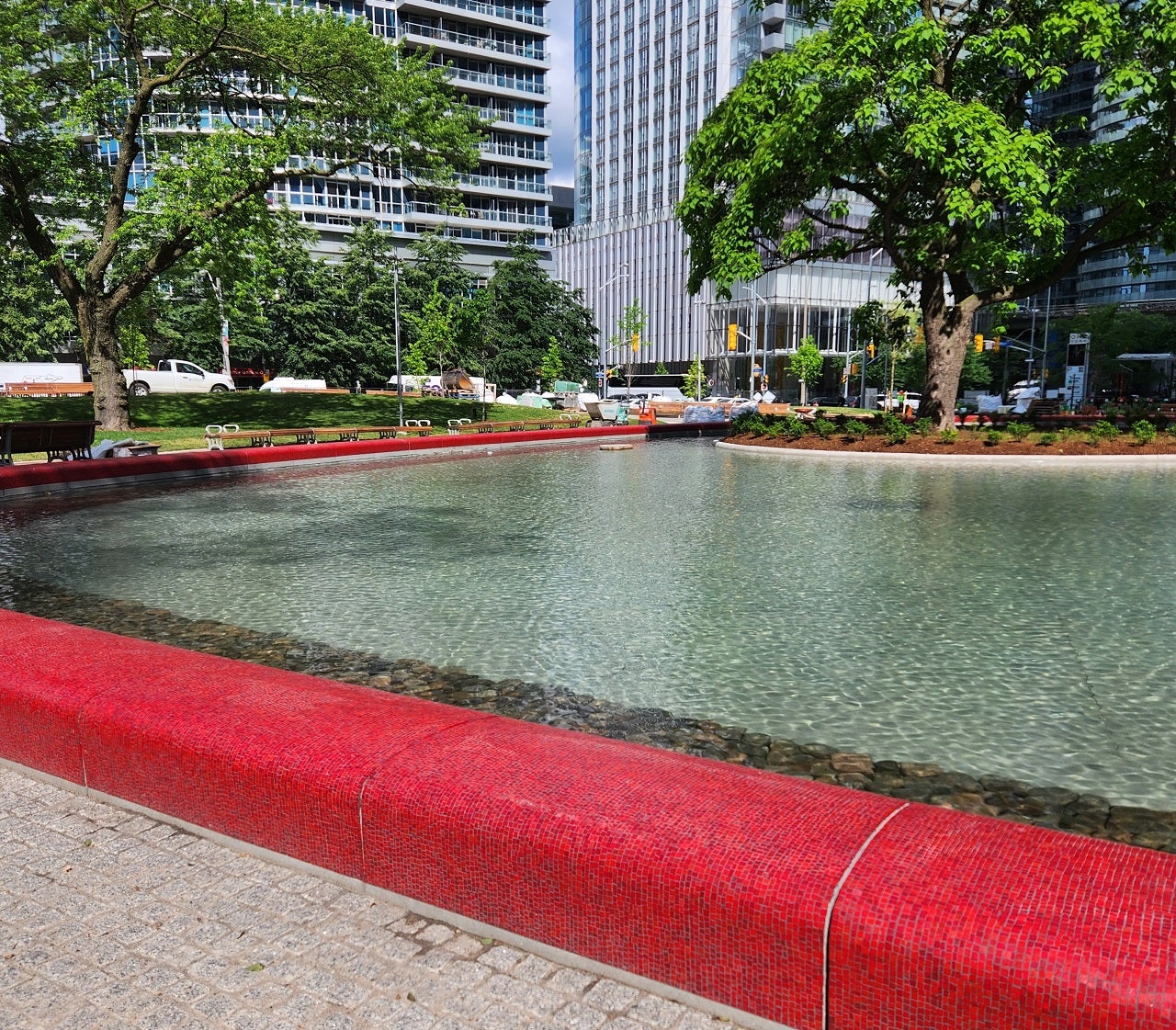 close up of a park's pond with a red tile border