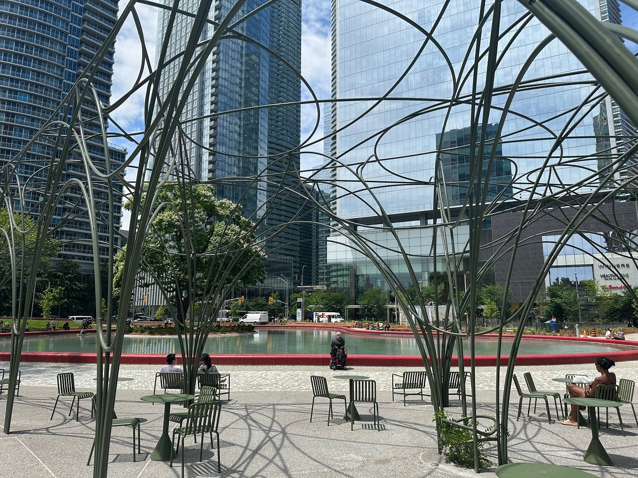 close-up of a trellis feature and tables and chairs in an urban park