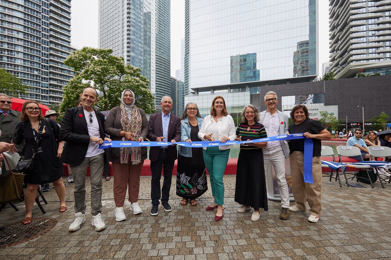 a group of people cutting a ribbon as part of an official park opening