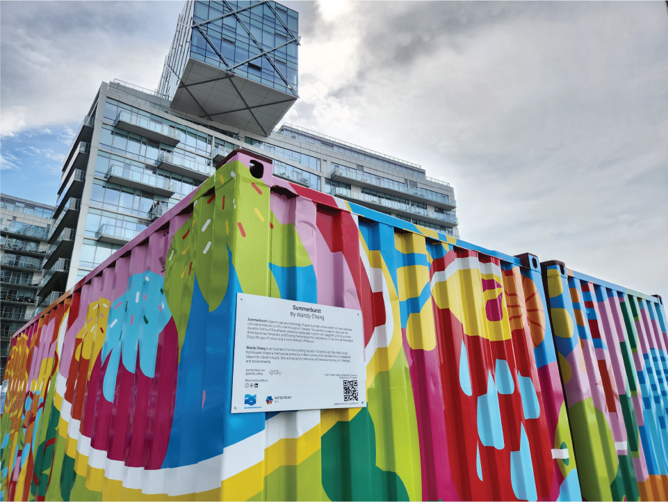 Two shipping containers covered in a vibrant mural. A residential tower in the background. 