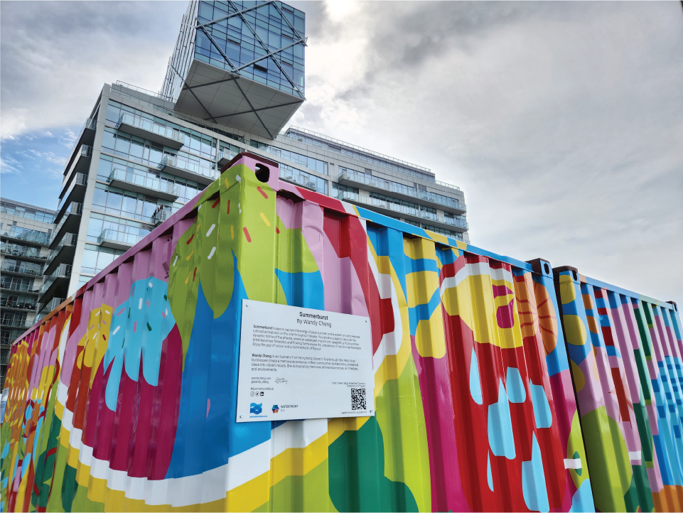 Two shipping containers covered in a vibrant mural. A residential tower in the background.