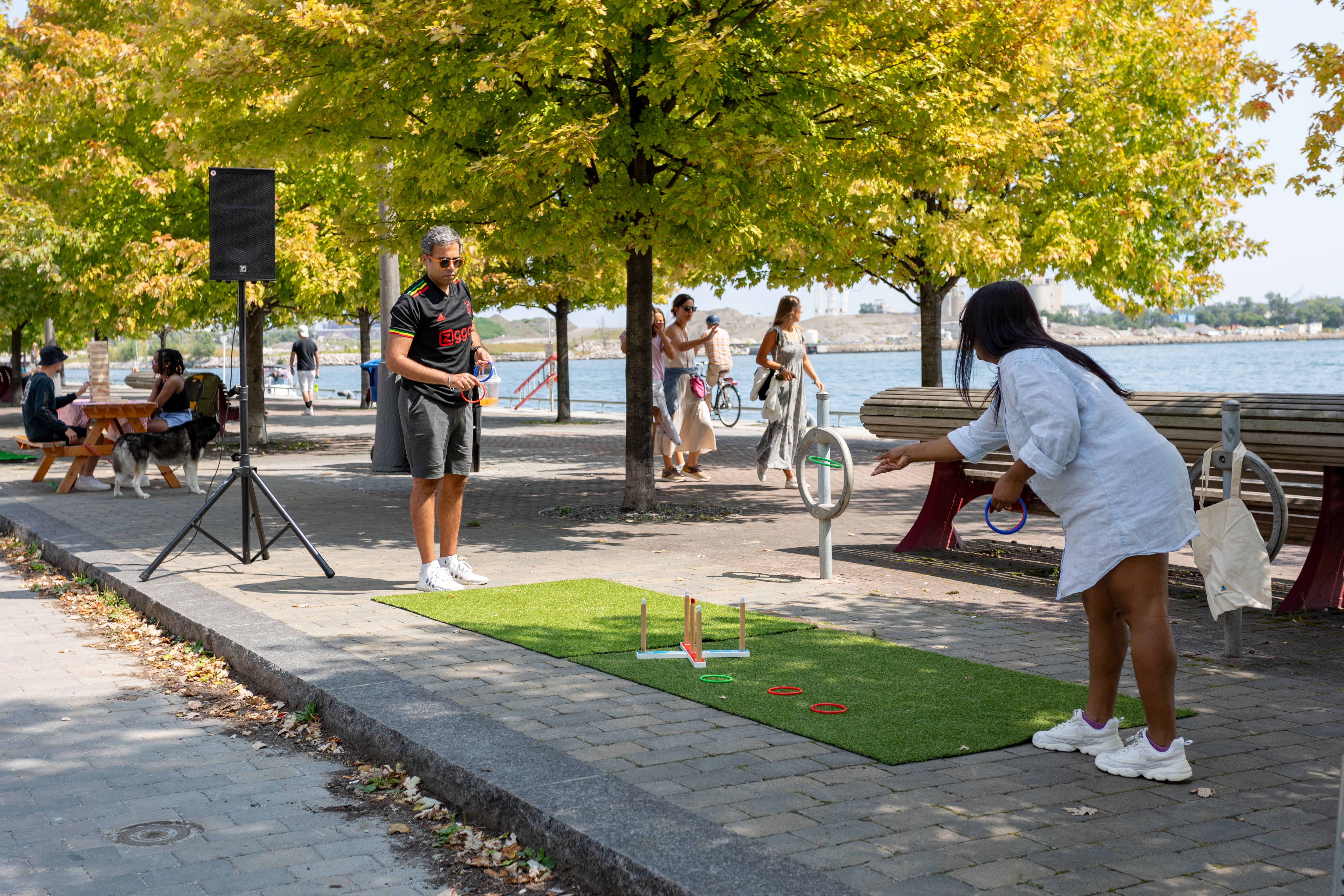 Two people play a game on the promenade along the waterfront.