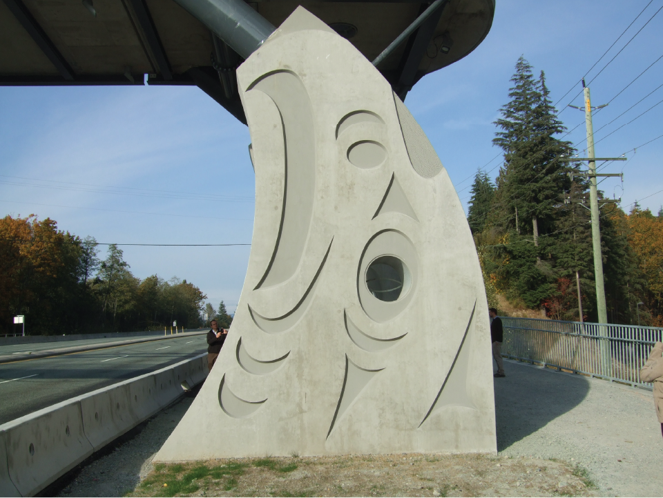 Thunderbird column on the side of a pedestrian bridge over a road.