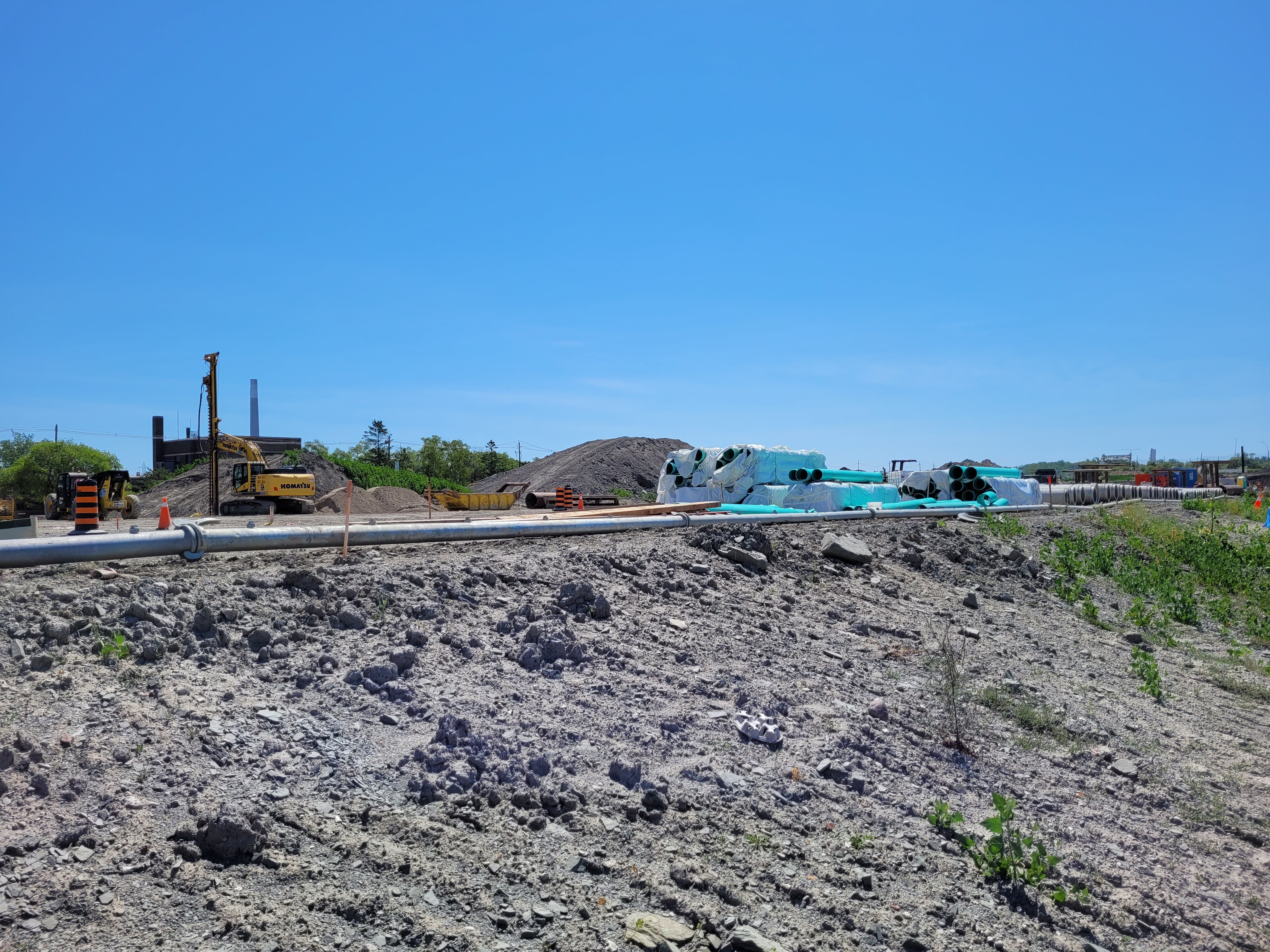 Excavator and in ground pipes in a construction site.