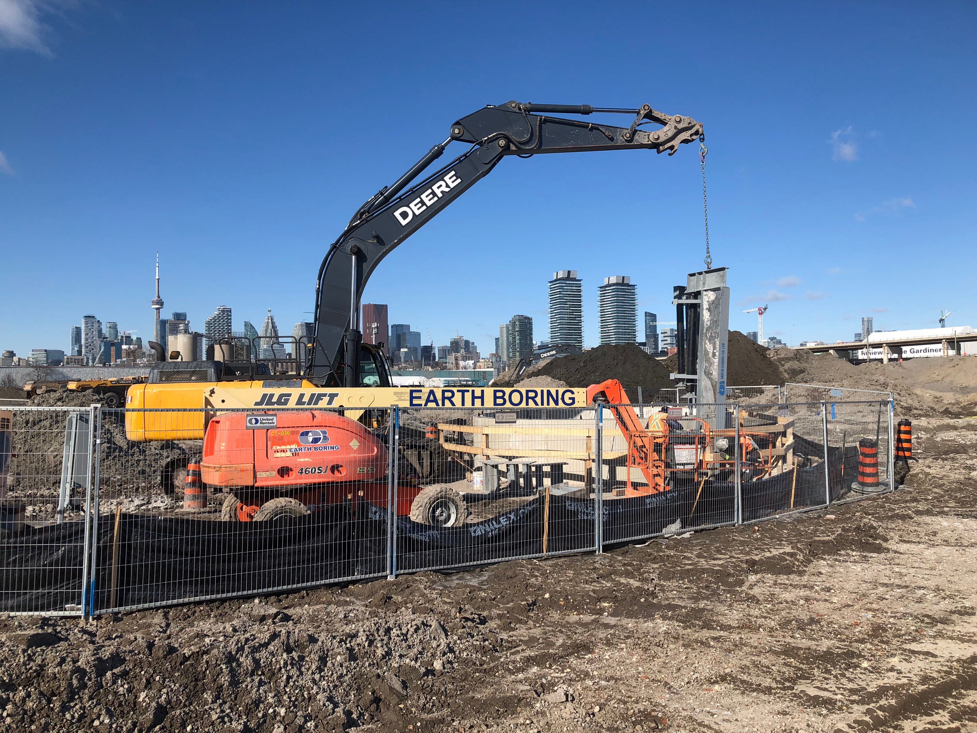 A large excavator over a city sky line. 