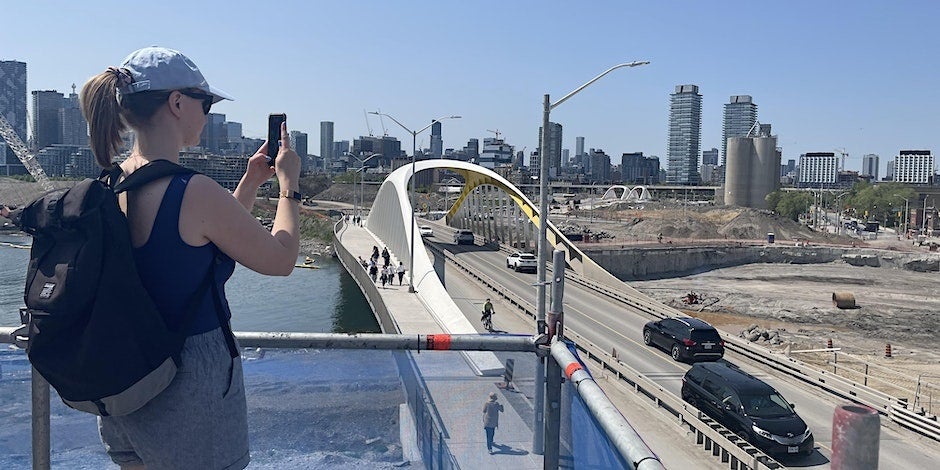 a person looking out at a construction site and view of a city