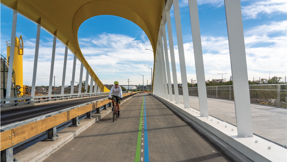 A cyclist in a bike lane on a bridge.