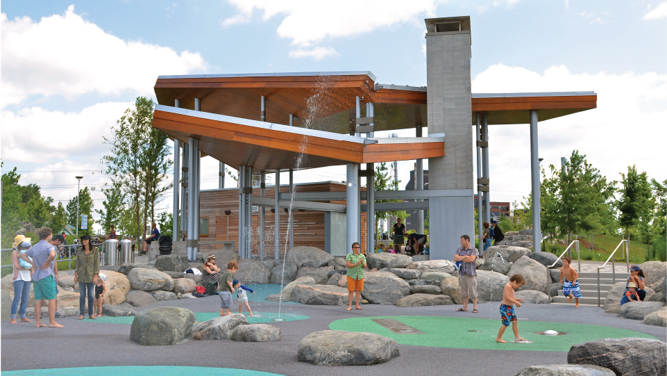 Families playing and enjoying the splashpad at Corktown Common park.