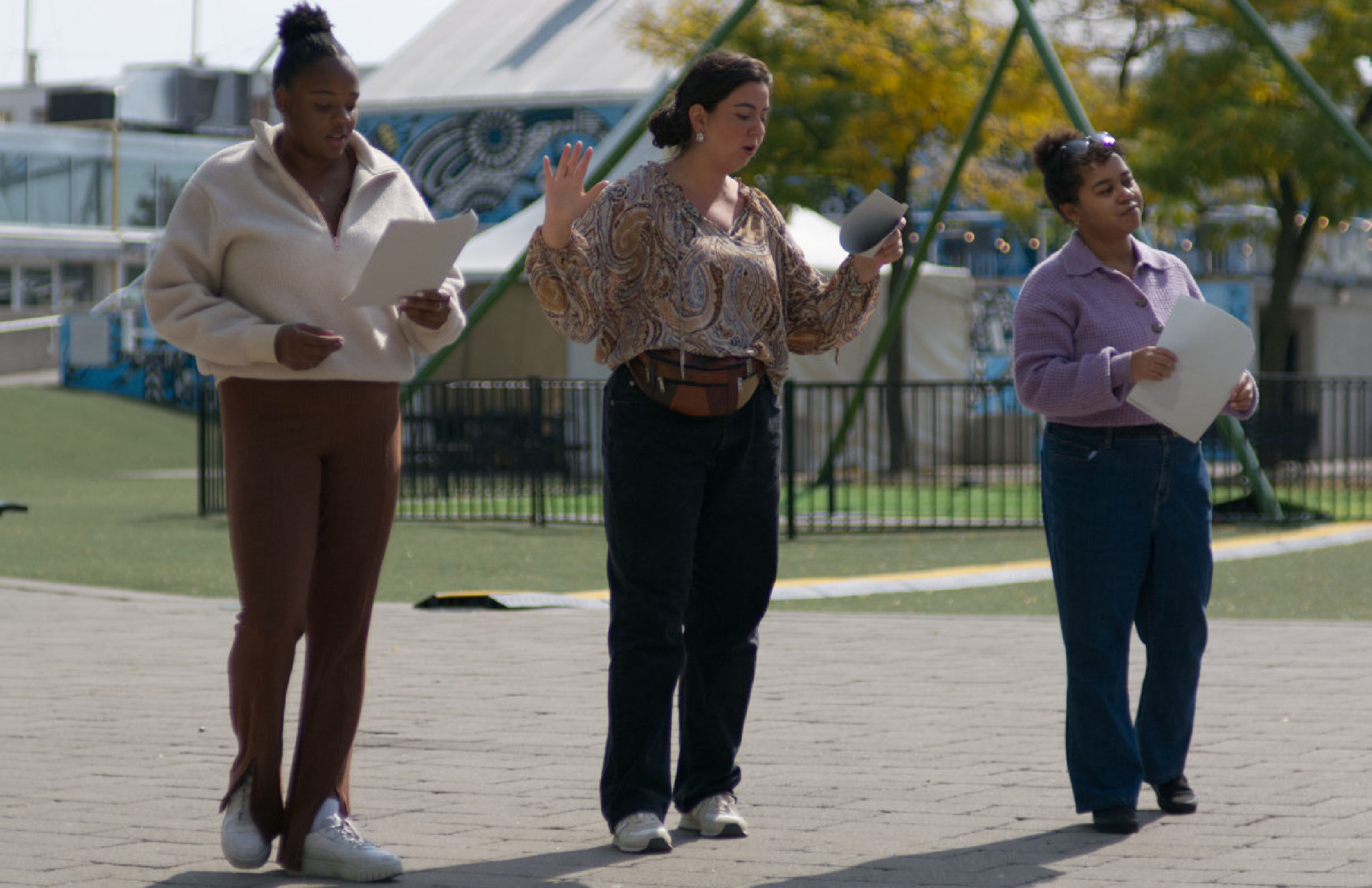 Three actors performing outdoors at Harbourfront Centre. 