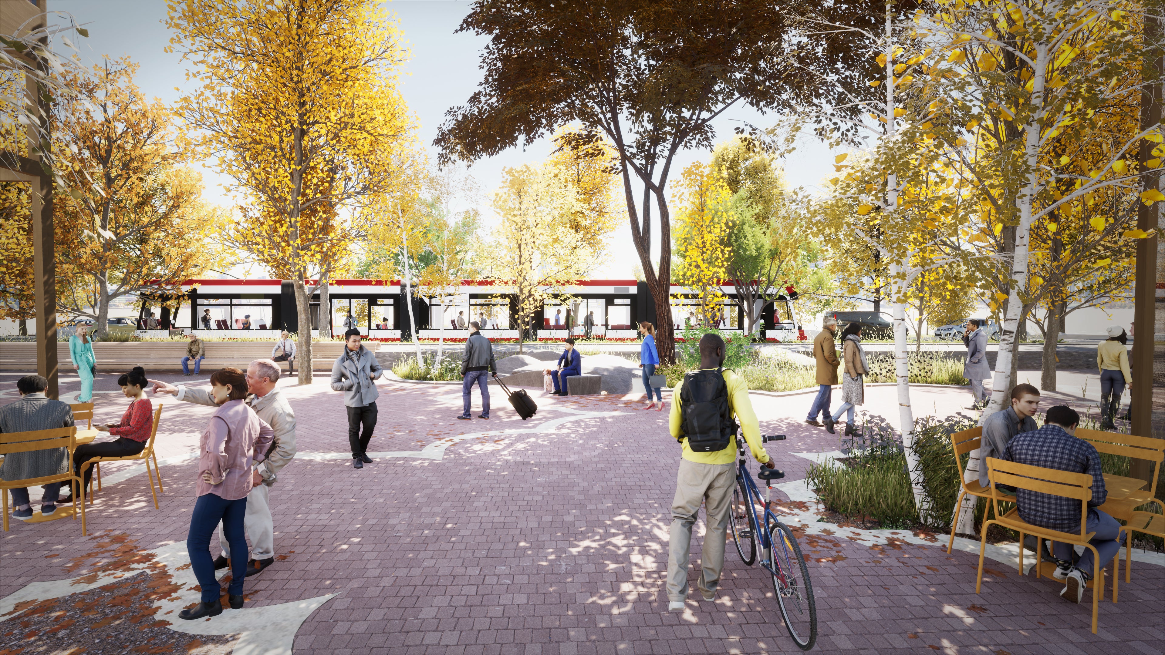 A bustling parkette beside a street with a streetcar passing by.