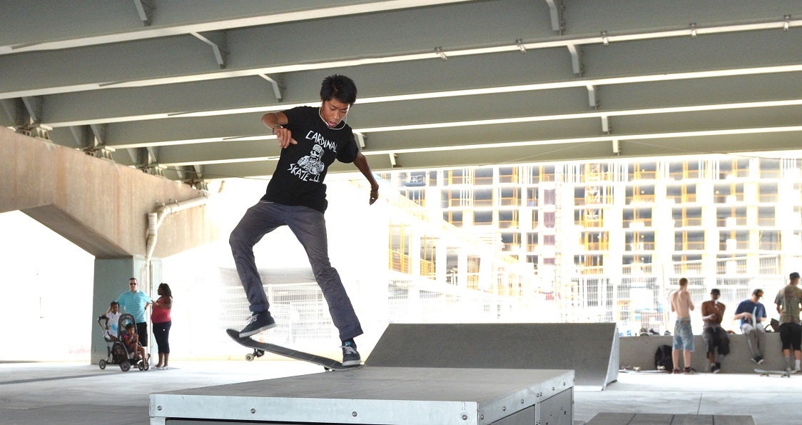 a person skate boards on new ramps at an urban park