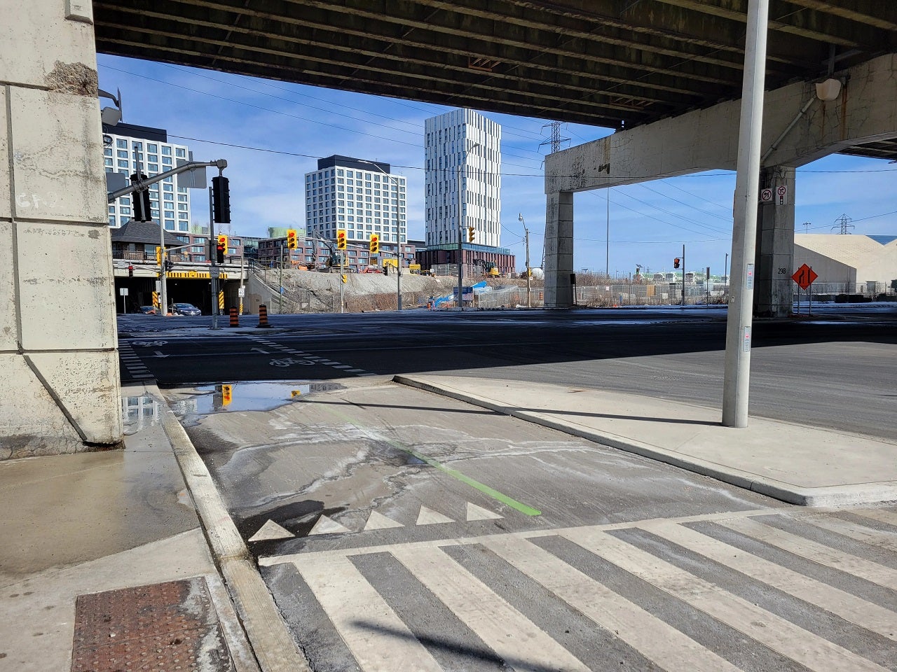 An intersection under a bridge. 