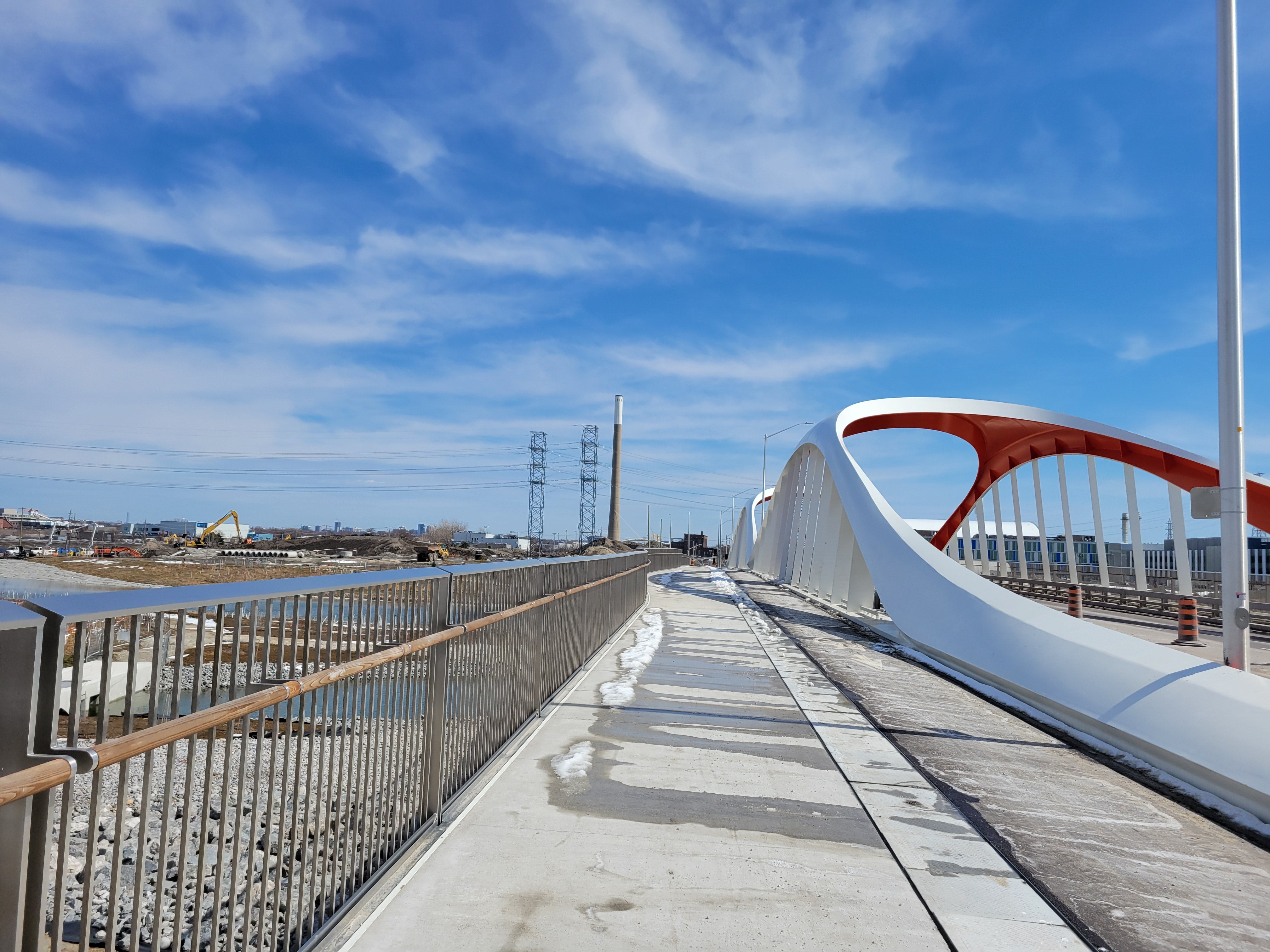 Looking toward a red and white bridge and sidewalk.