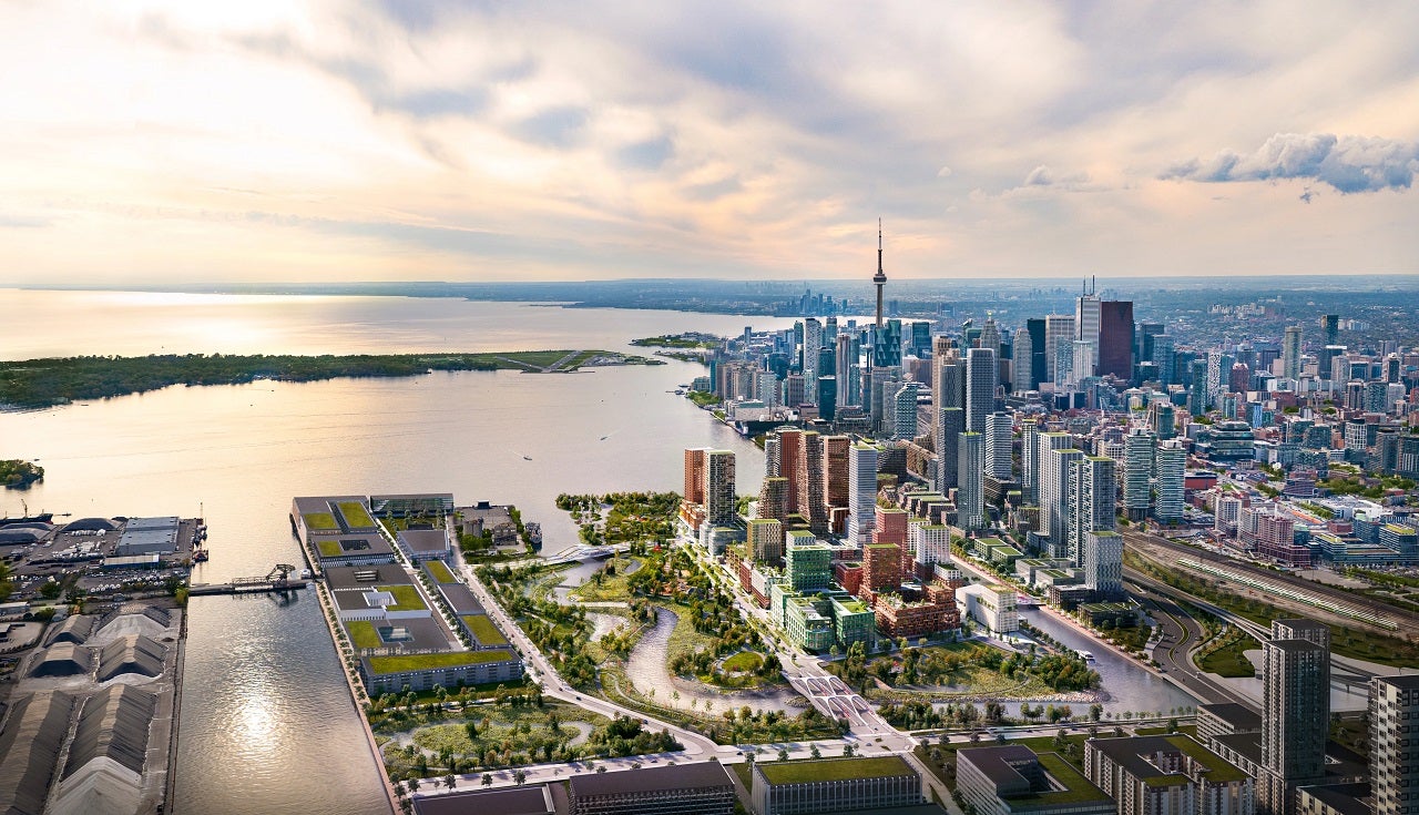 Artists rendering of a neighbourhood made up of buildings of varying heights, surrounded by parks and a river.