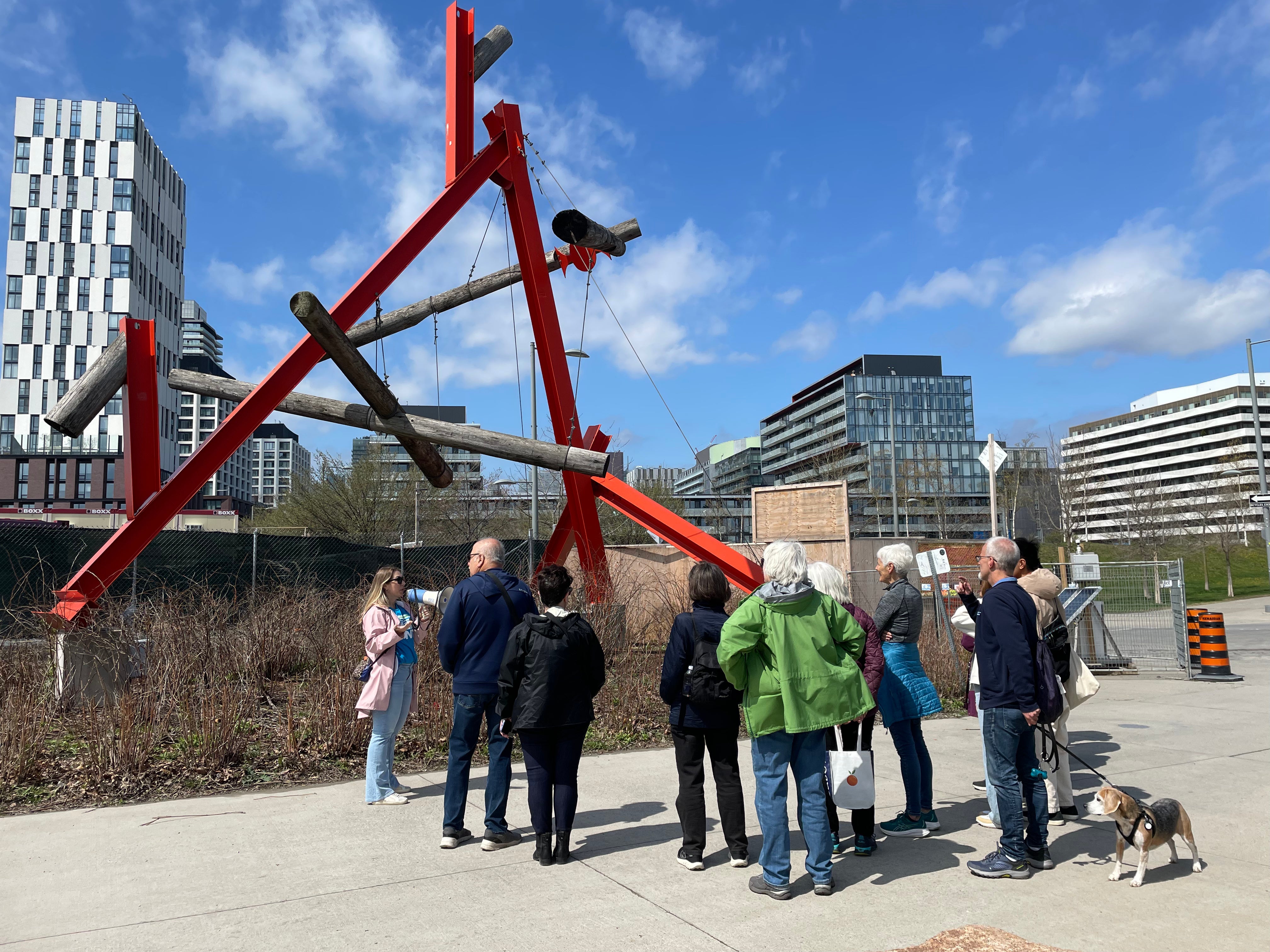 People observing the artwork No Shoes in West Don Lands on a bright sunny day.