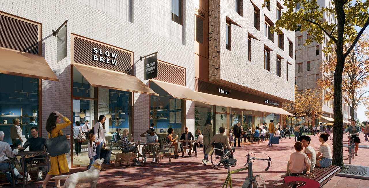 Outdoor scene at a bustling city street with individuals dining and socializing at "Slow Brew" and "Thrive" cafes under sunshades, with pedestrians and cyclists passing by.