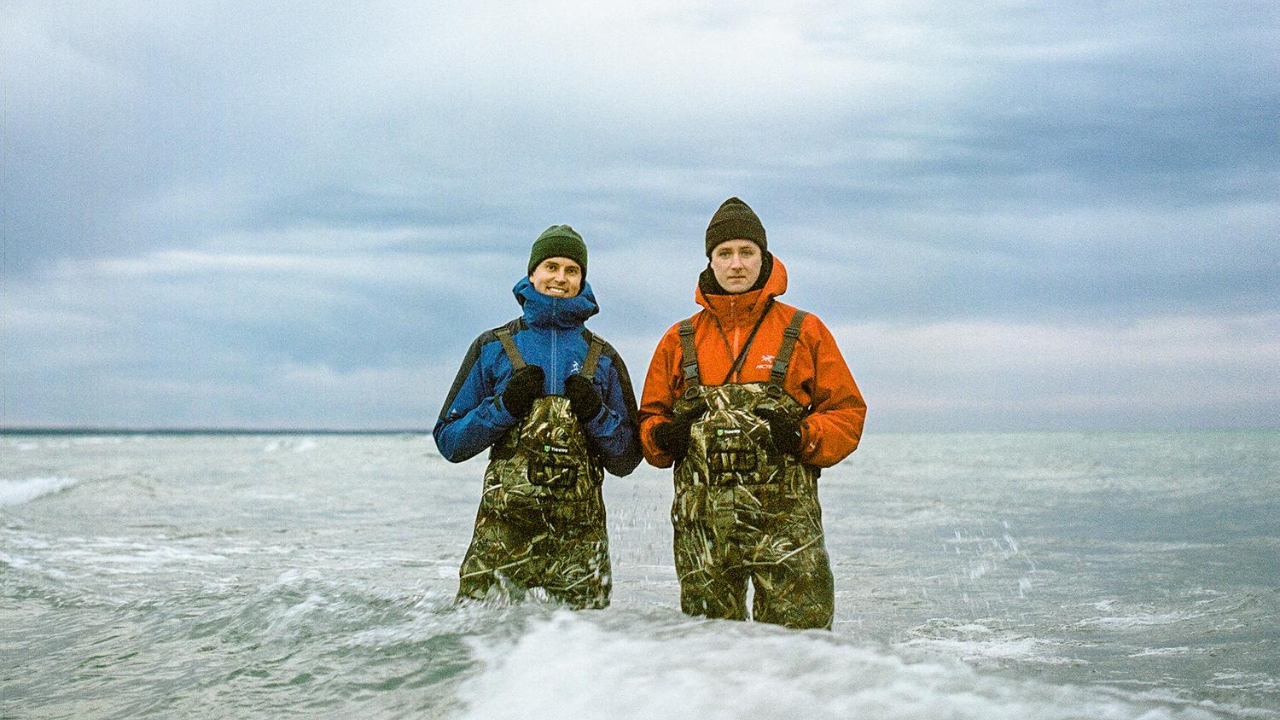 Global Convenience Artists Trevor Wheatley (left) and Cosmo Dean (right) standing knee deep in the lake.