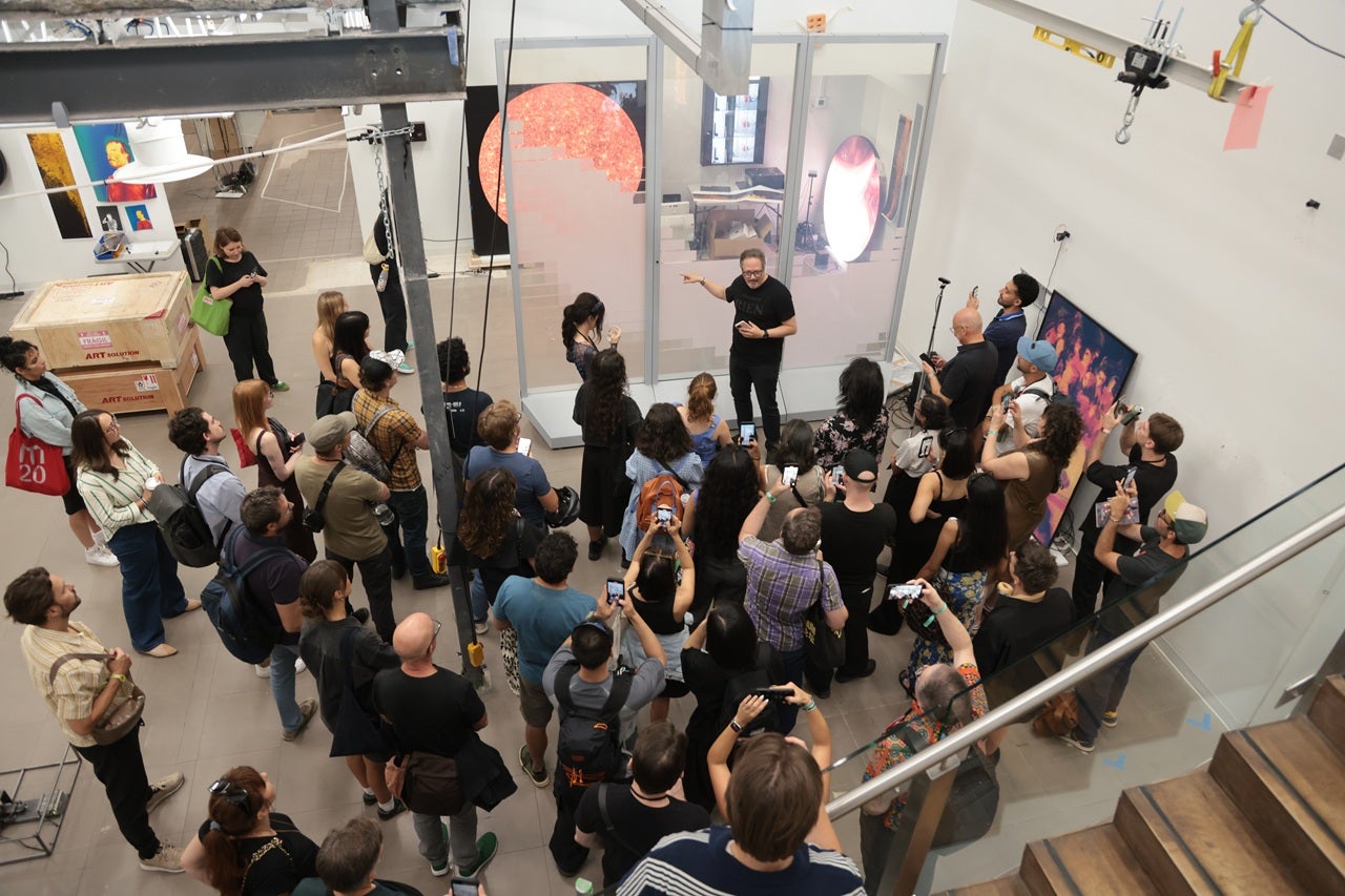 Overhead view of a group of people standing in an artist studio