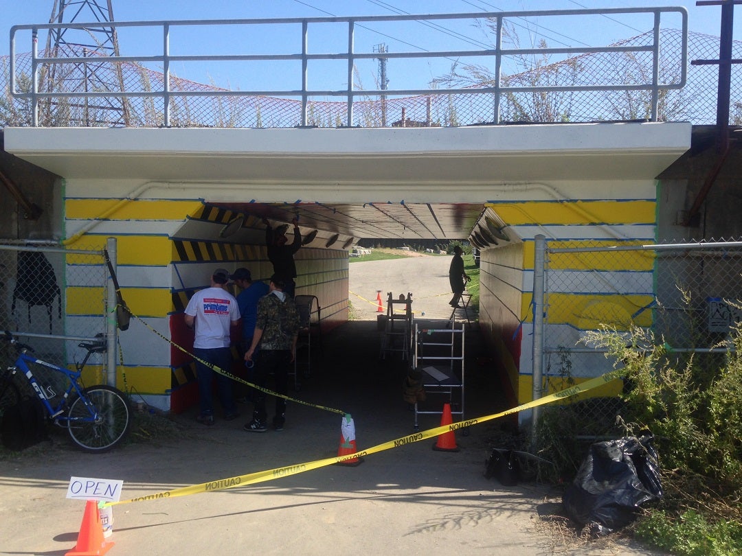 Crews at work installing Rolande Souliere's mural at the Bala Underpass.