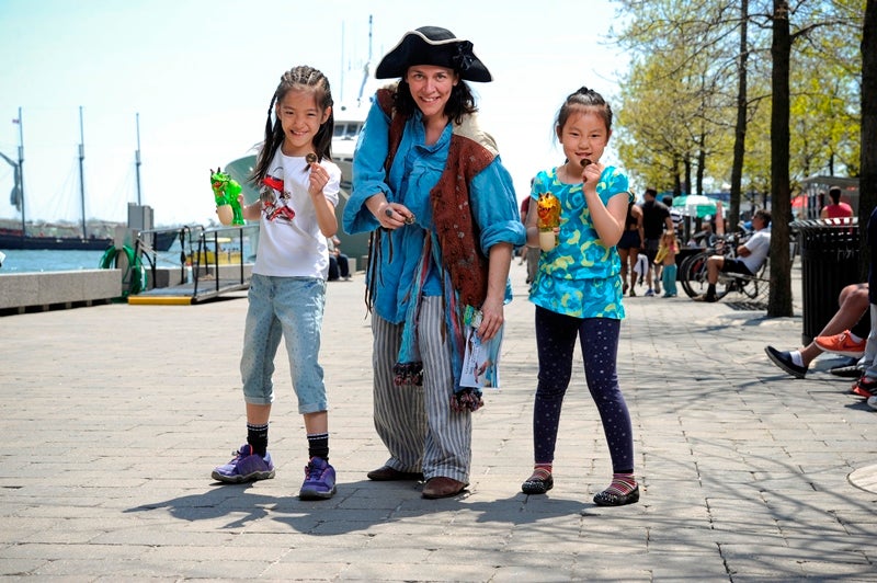 a pirate with two children at the water's edge