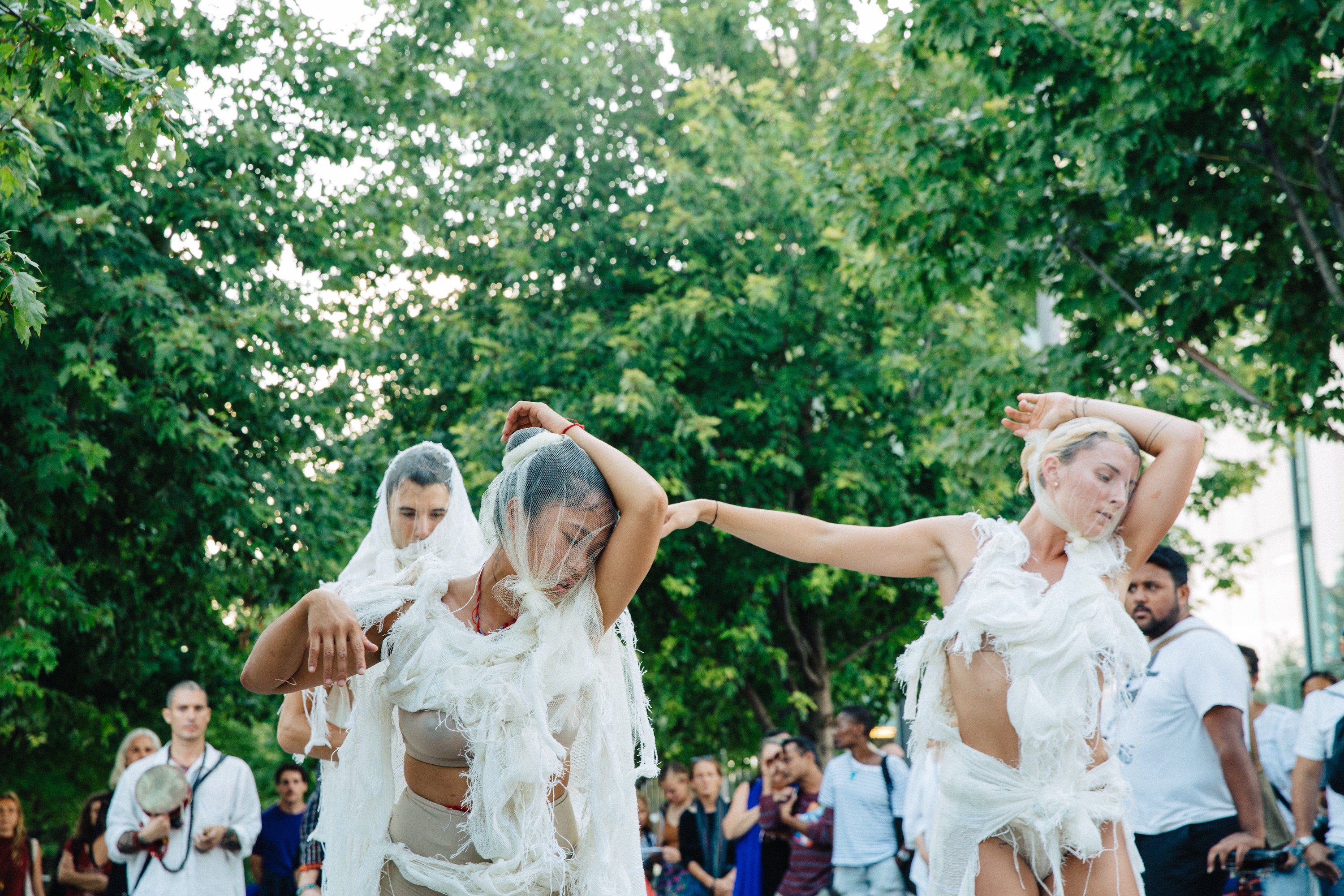 Performers draped in white make their way down the water’s edge promenade to Sherbourne Common.