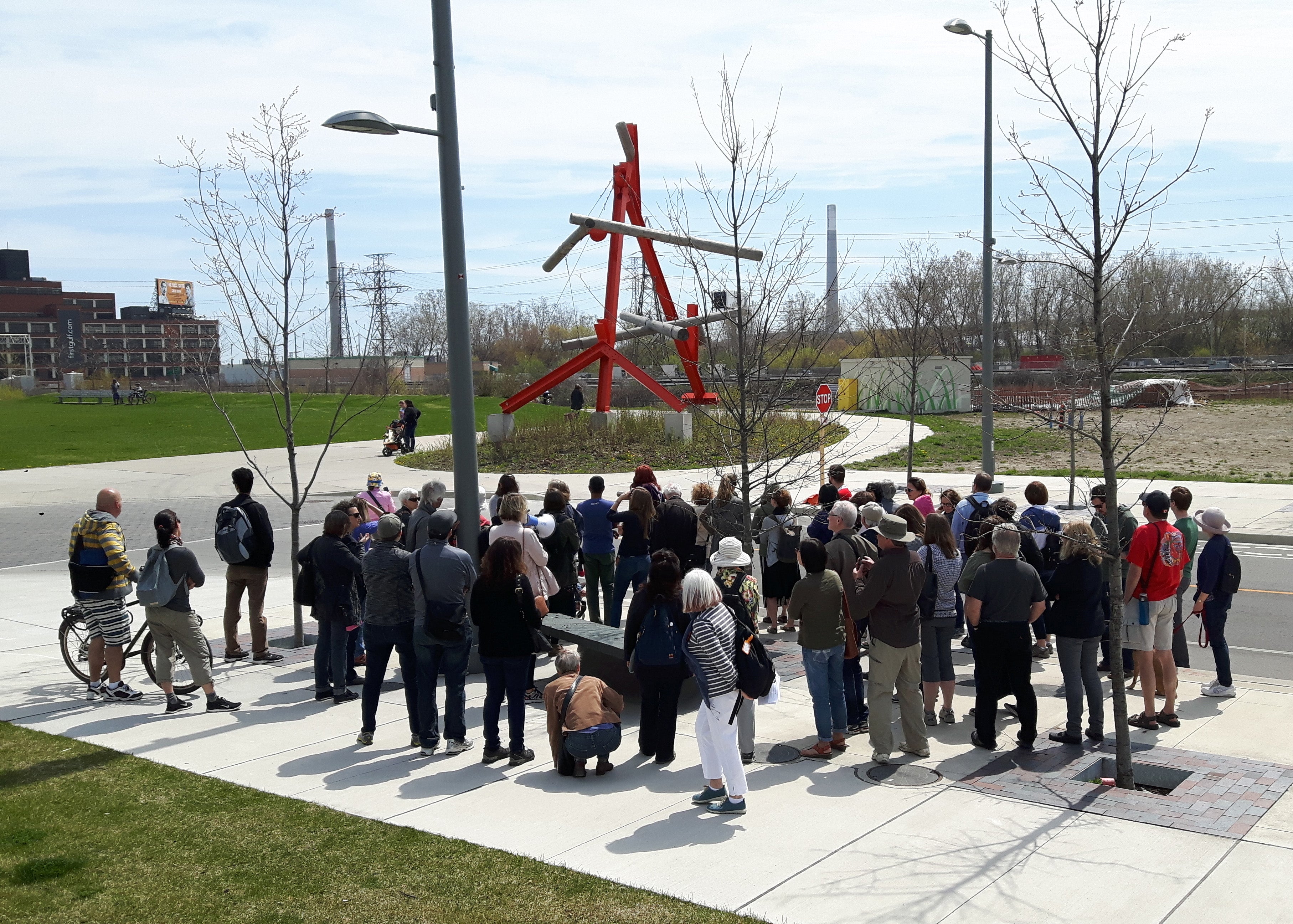 Participants gather around No Shoes during the Jane’s Walk public art tour in the West Don Lands.