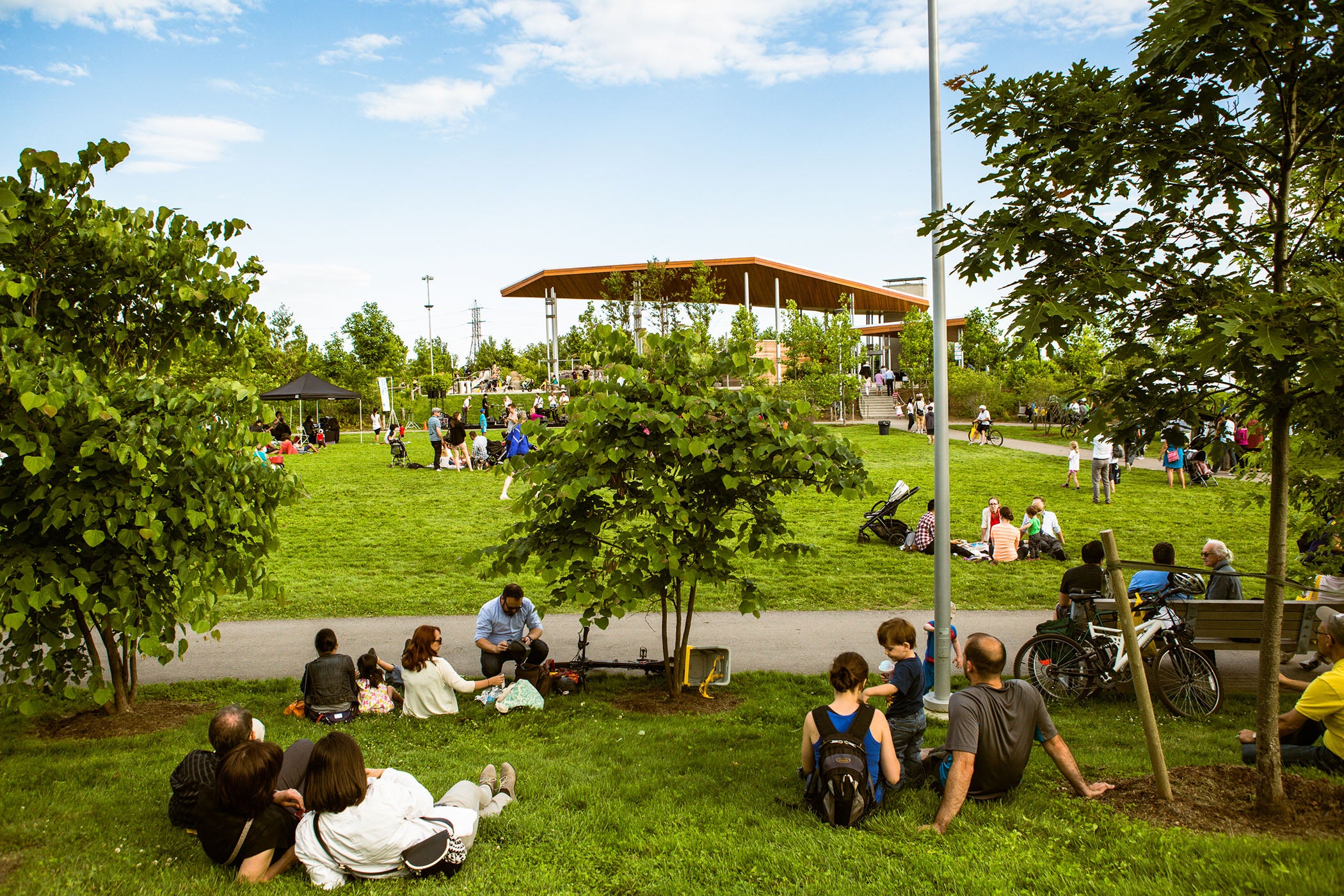 Visitors of all ages lounge on the grassy open lawns at Corktown Common.