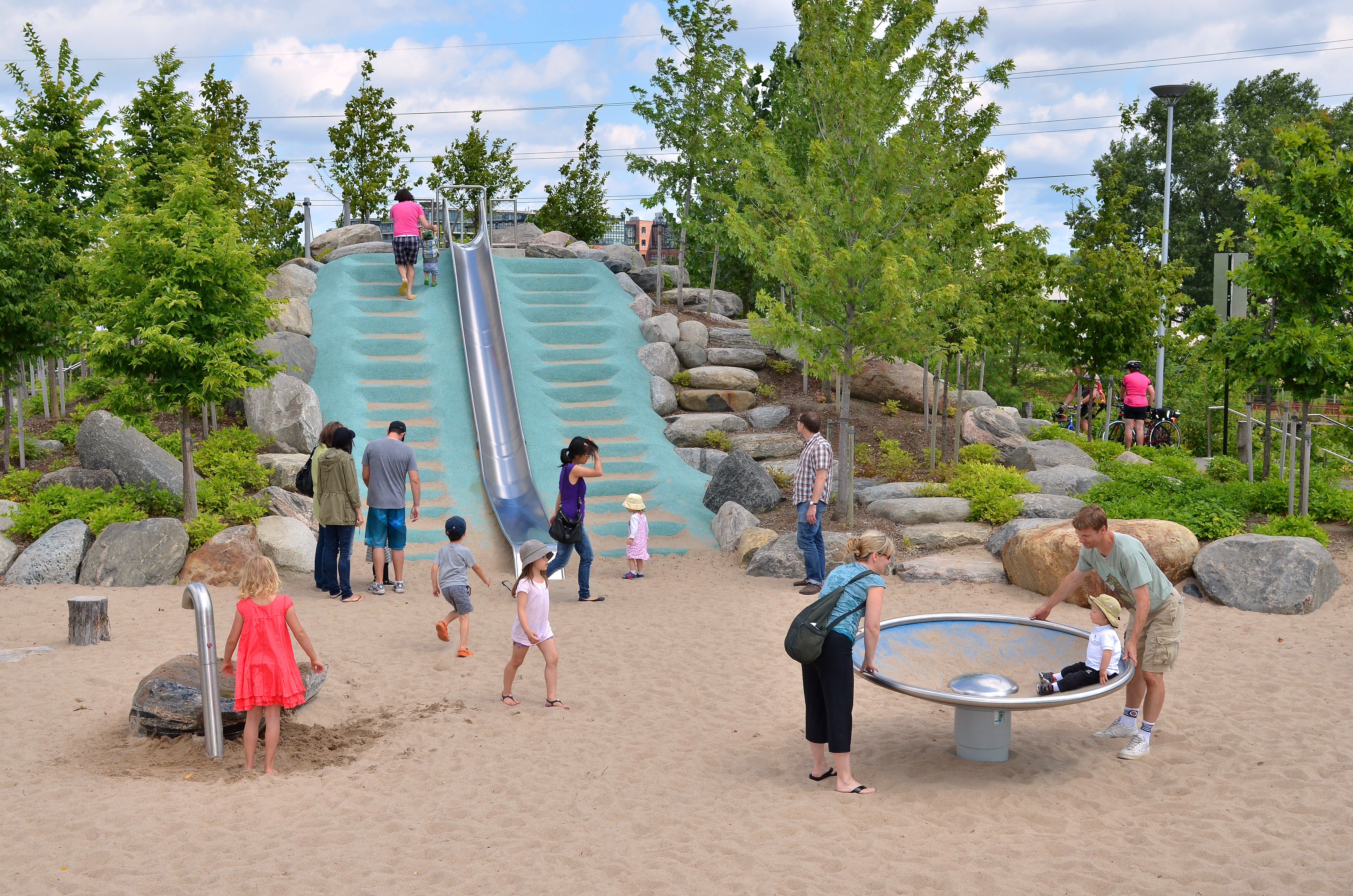 Park-goers at play on the sloped grounds at Corktown Common.