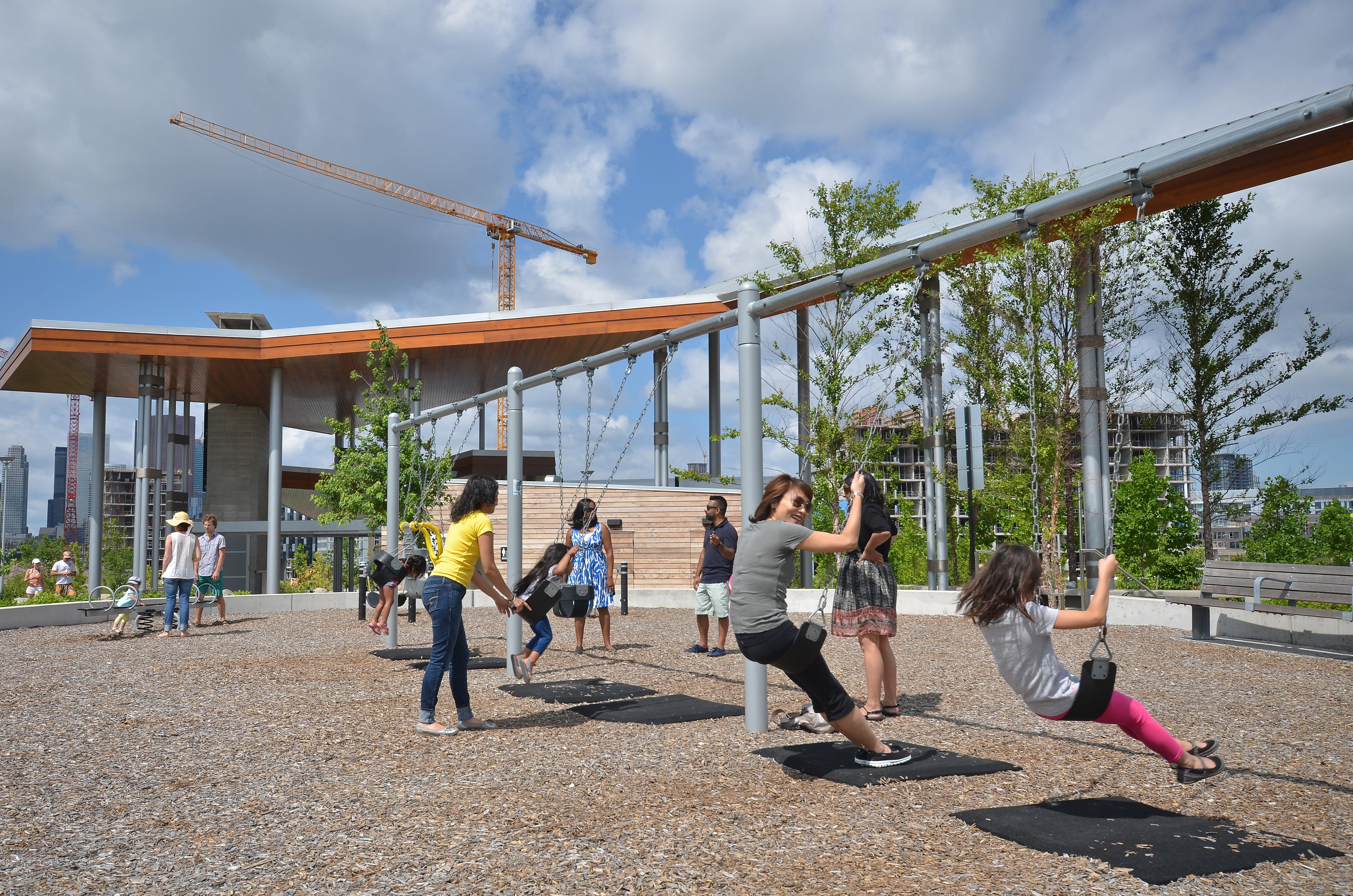 Park-goers at play on the swing set at Corktown Common.