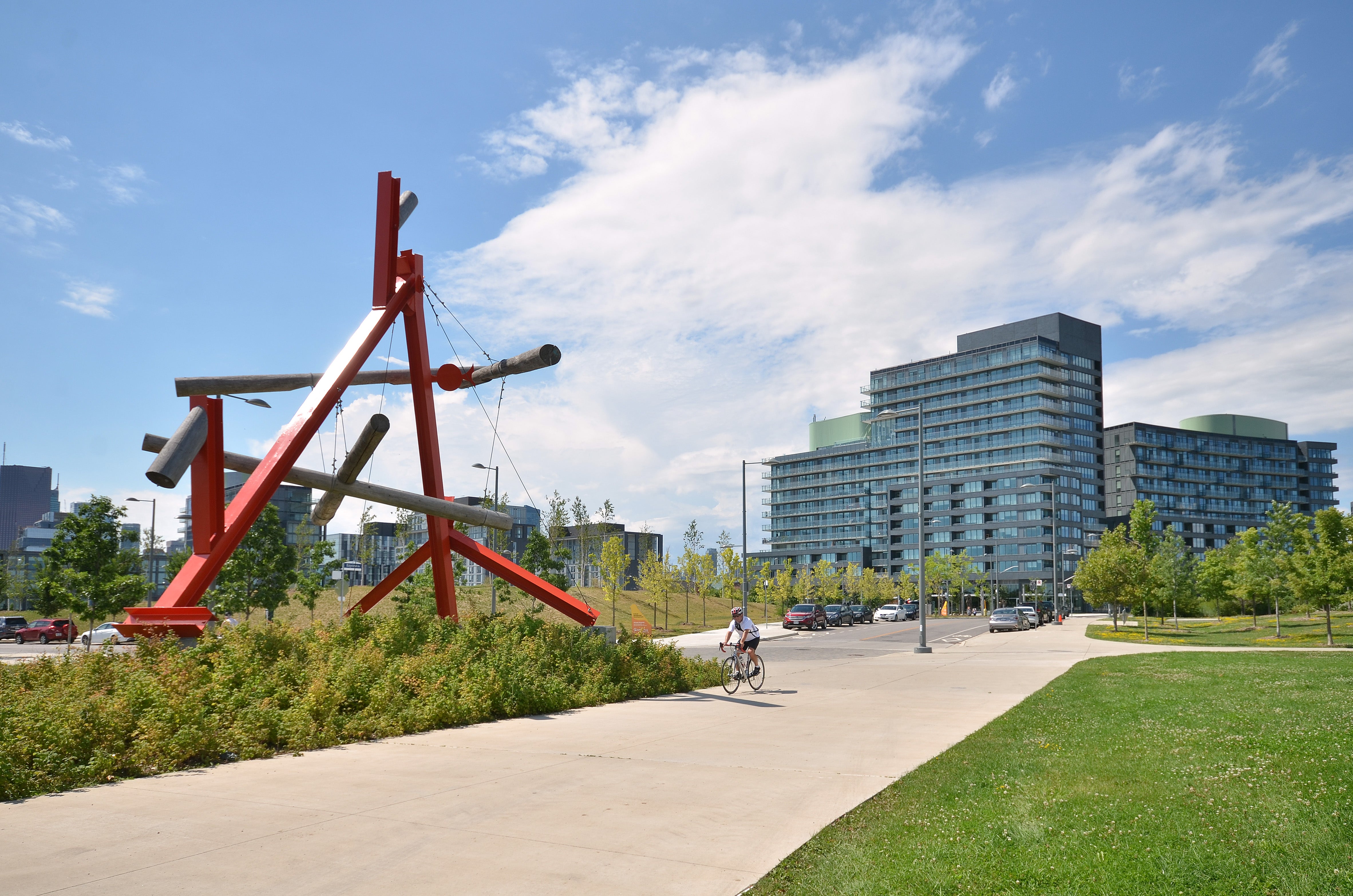 The large scale of “No Shoes” is revealed by a passing cyclist and adjacent buildings.