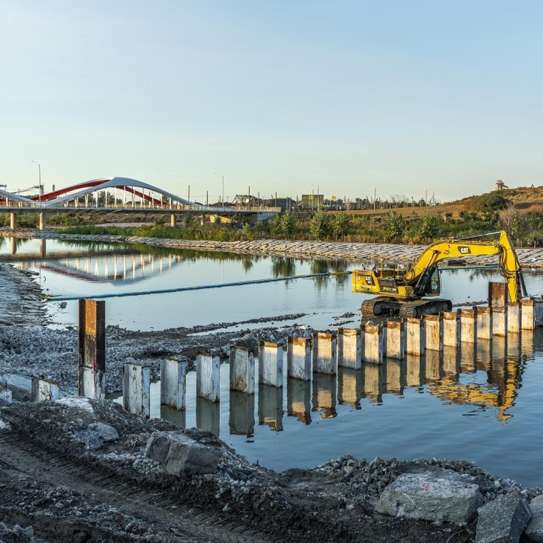 An excavator removing part of the north plug of a river.