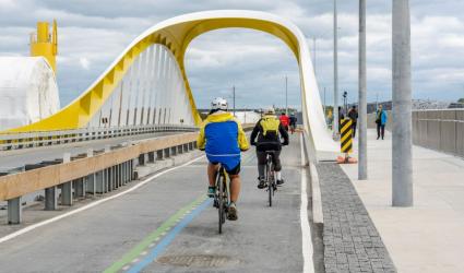 cyclists riding across a bridge