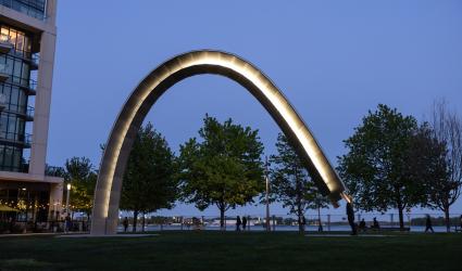 A large public art arch is activated by the artist and lit up at night